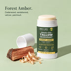 Forest Amber grass-fed tallow deodorant with its cap off, beside split cedar and wood shavings. Forest Amber. Cedarwood, sandalwood, vetiver, patchouli.