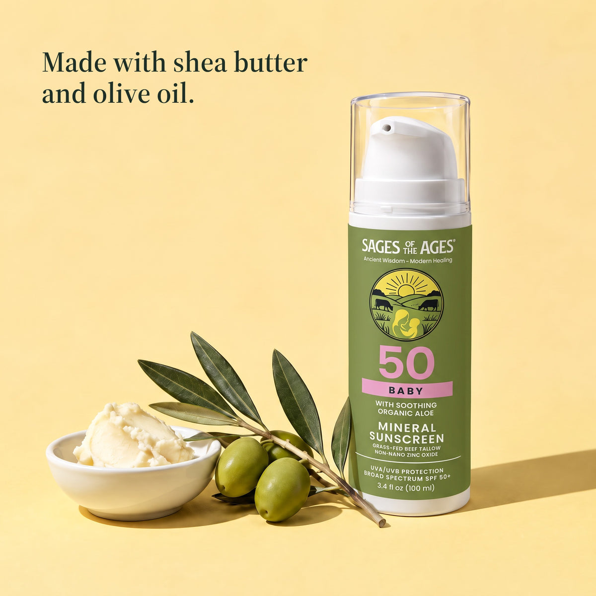 Baby mineral sunscreen pump bottle beside a bowl of shea butter and an olive branch. Made with shea butter and olive oil.