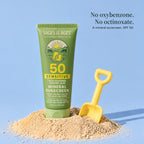 Tube of SPF 50 mineral sunscreen lotion set in a heap of sand with a yellow toy spade. No oxybenzone. No octinoxate. A mineral sunscreen, SPF 50.