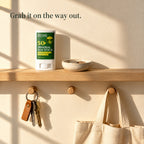 SPF 50 mineral sun stick on a hallway shelf above hanging keys and a tote bag. Grab it on the way out.