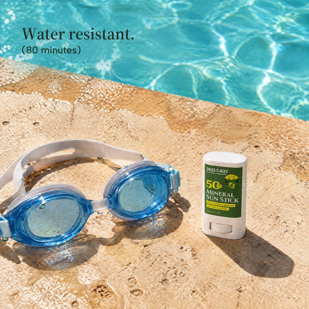 SPF 50 mineral sun stick on the edge of a pool beside a pair of wet swim goggles. Water resistant. 80 minutes.
