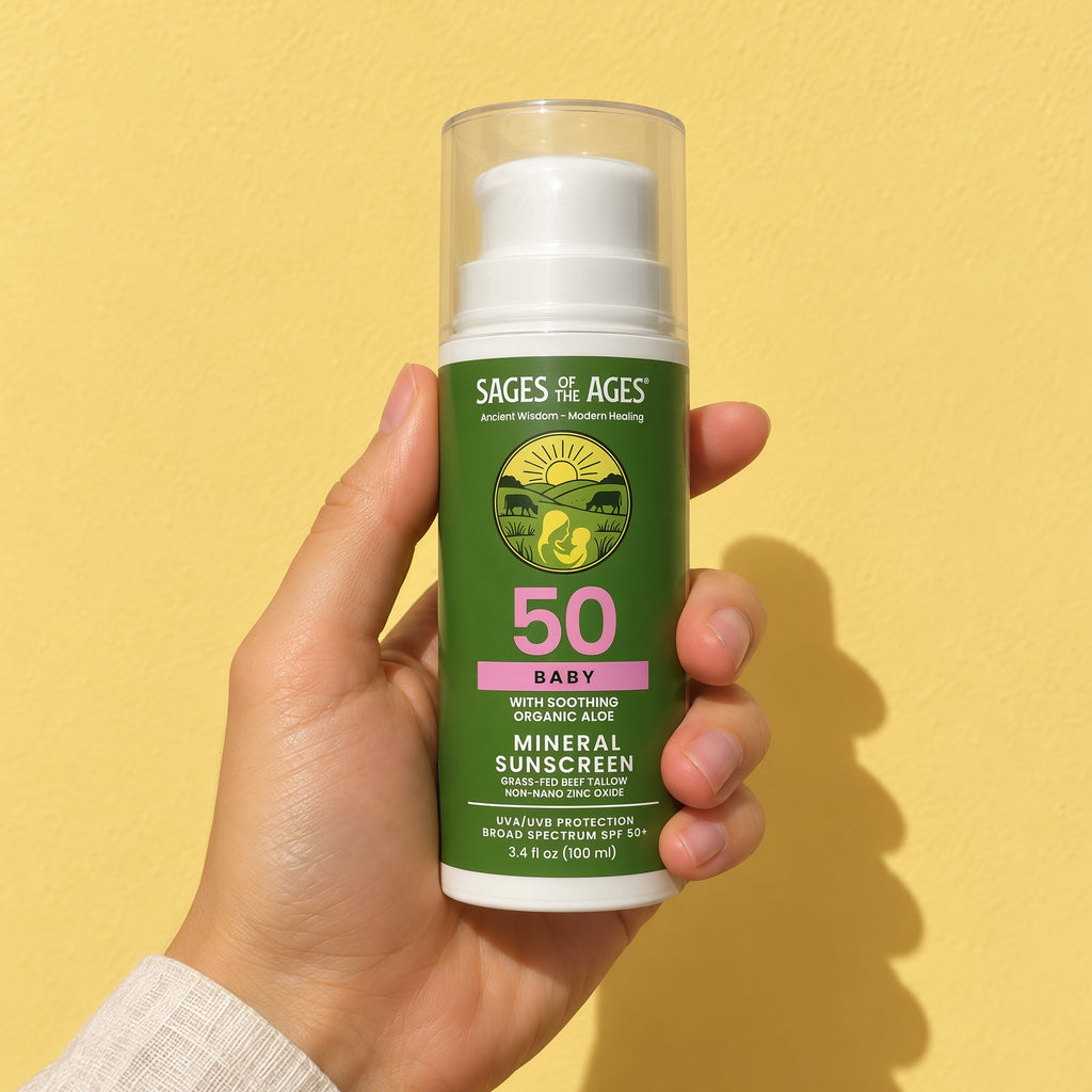 A hand holds up the baby mineral sunscreen SPF 50 pump bottle against a yellow wall.