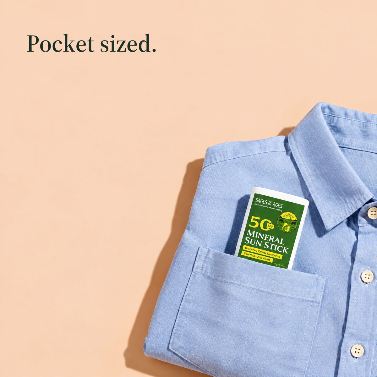 SPF 50 mineral sun stick tucked in the pocket of a folded blue shirt. Pocket sized.