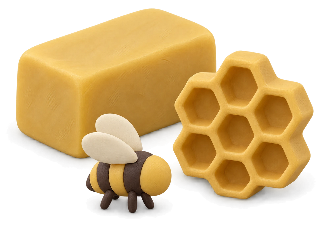 A block of yellow clay beeswax, a piece of honeycomb and a small clay bee